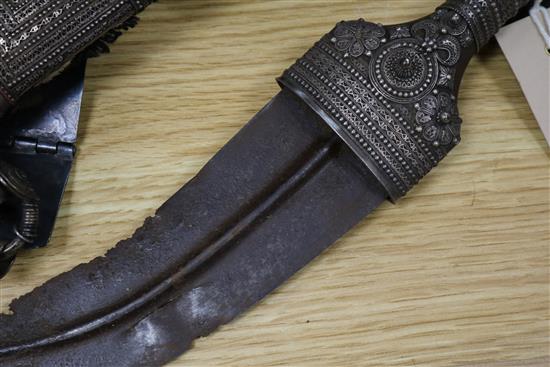 An Omani khanjar in decorative white metal-mounted wooden scabbard on woven belt and two other items,